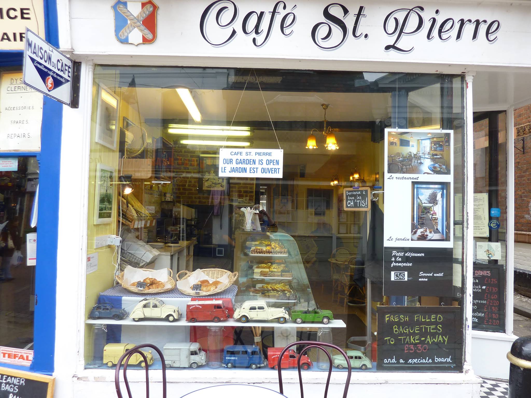 Cafe St Pierre’s shopfront with its full sign, blue window trim and pastry counter.